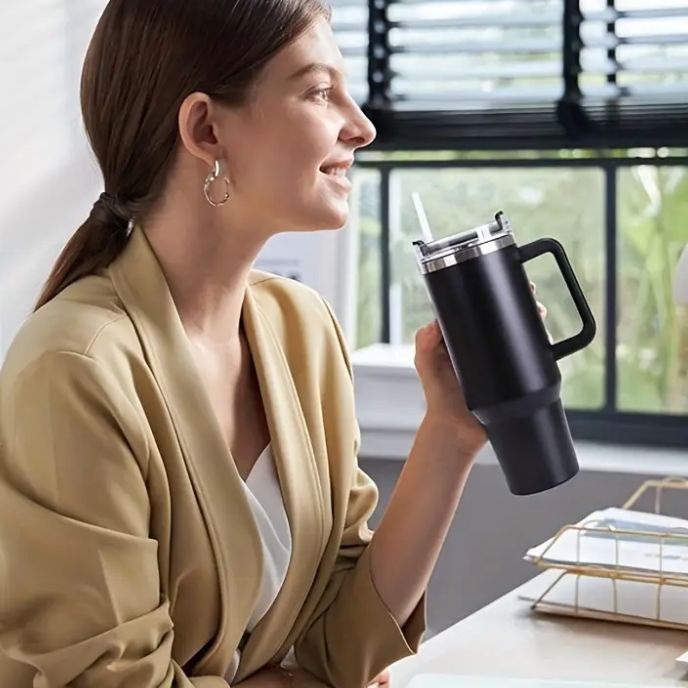 femme-au-bureau-avec-gourde-isotherme-noire-à-la-main