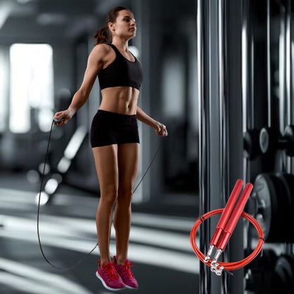 jeune femme saute avec corde a sauter crossfit rouge dans salle de fitness