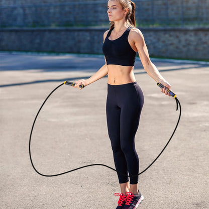 Séance de corde à sauter connectée en plein air pour une jeune femme active concentrée sur son entraînement cardiovasculaire