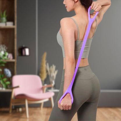 femme etire elastique musculation violet avec deux mains en position debout elastique derriere son dos dans salon