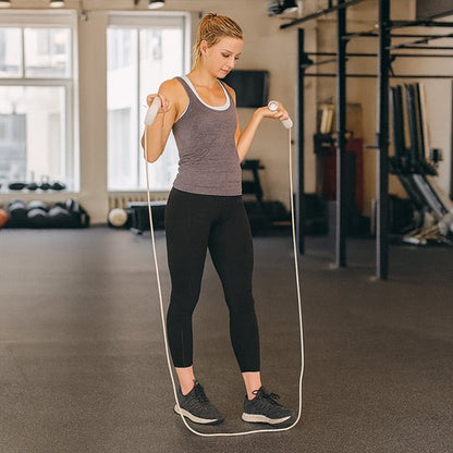 Femme pratiquant des sauts à la corde a sauter dans une salle de sport moderne