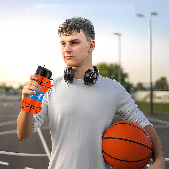 garçon-tient-gourde-de-sport-à-une-main-et-ballon-de-basket-dans-l-autre-main