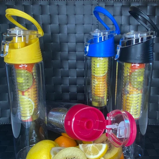 Quatre gourde plastique avec infuseur posées avec des fruits tranchés