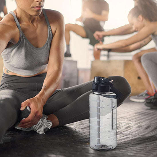 femme-assise-fait-des-étirements-avec-sa-gourde-pour-le-sport-à-côté-d-elle