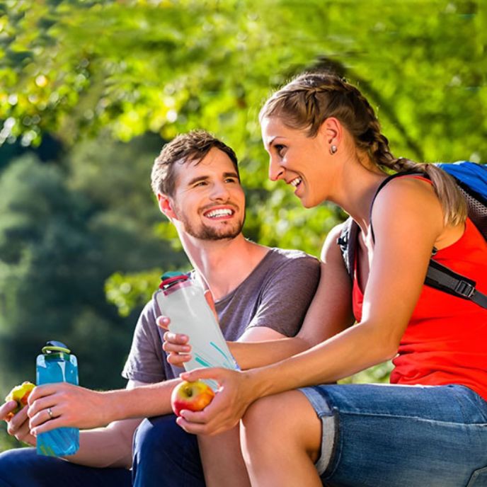 femme et homme discutent tenant gourde pour le sport à la main