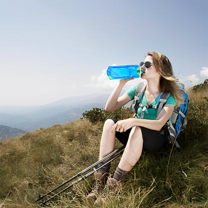 femme assise sur montagne boit de gourde pour le sport bleue