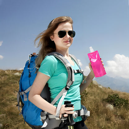 femme tenant gourde pour le sport rose à la main dans la montagne
