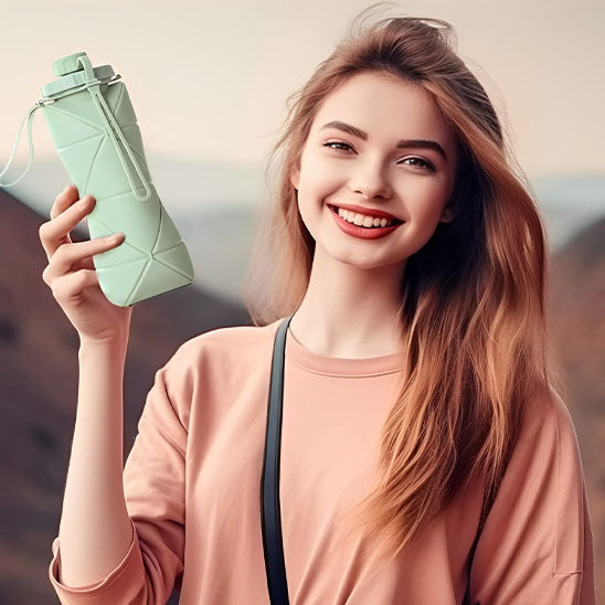 femme-souriante-tenant-gourde-sport-à-la-main