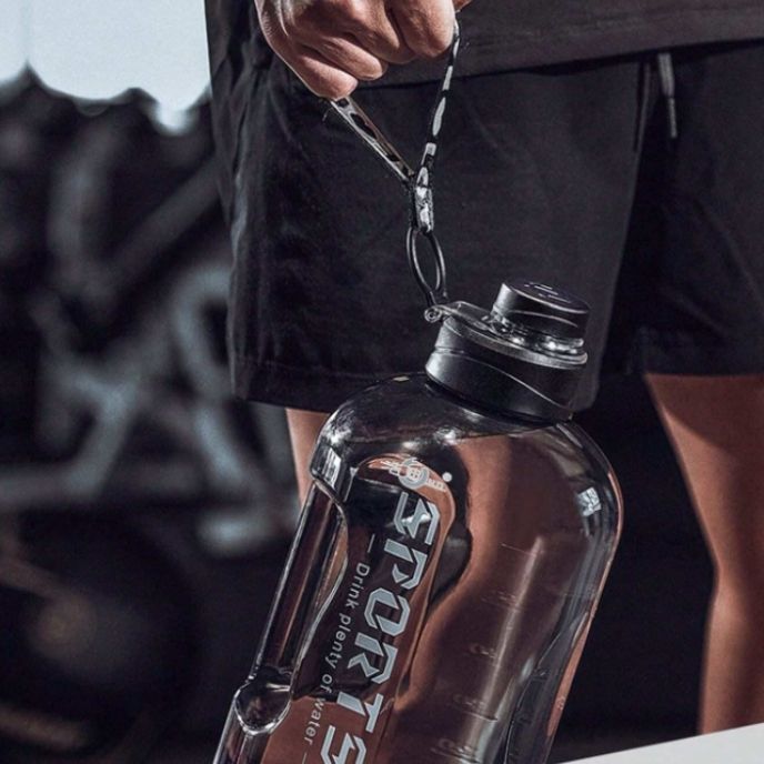 homme-tient-gourde-sport-par-sa-corde