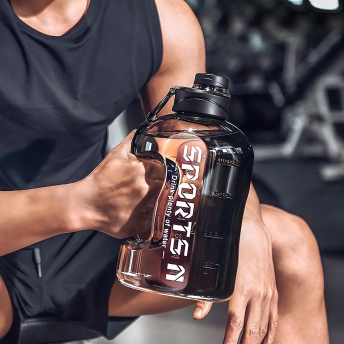 homme-assis-tenant-gourde-sport-à-la-main