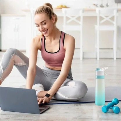 femme-sur-tapis-de-sport-devant-ordinateur-portable-avec-gourde-sport-à-côté