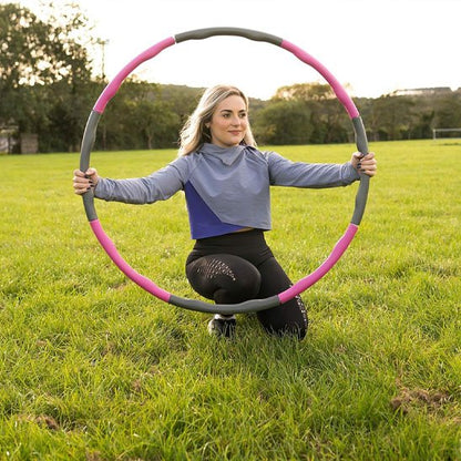 hula hoop extérieur pratiqué par une femme en séance fitness en plein air