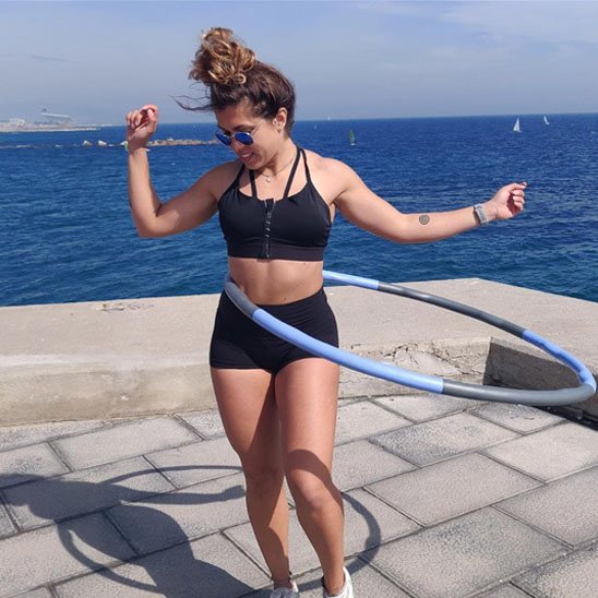 Hula hoop fitness pour femme utilisé en bord de mer