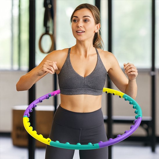 Hula hoop sport utilisé par une femme lors d’un entraînement en salle parfait pour travailler la taille et la coordination