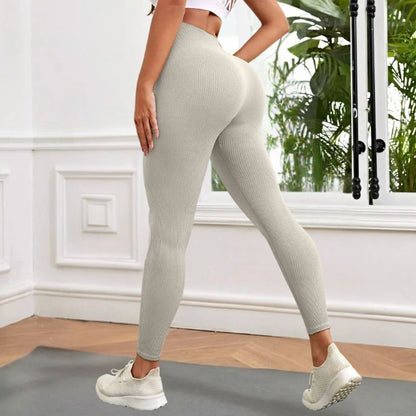 femme porte legging sport beige vue de côté dans sa chambre