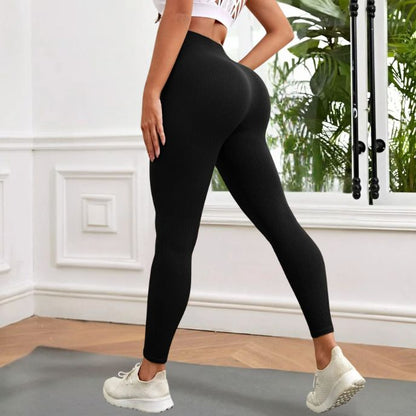 femme porte legging sport noir vue de côté dans sa chambre