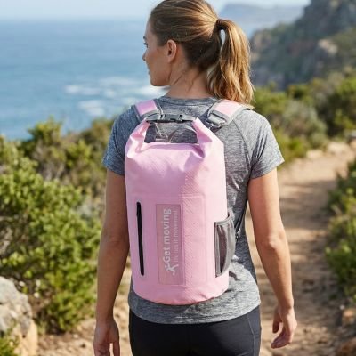 femme porte sac à dos étanche rose dans une montagne