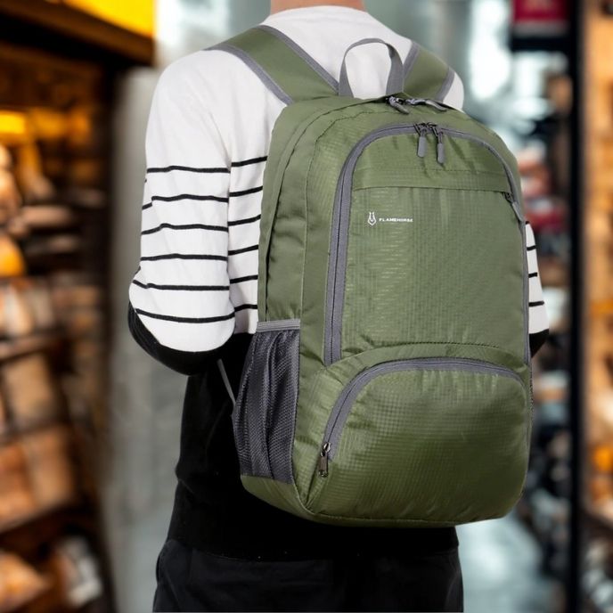 Un sac a dos pour sport vert avec finitions grises porté dans un environnement intérieur moderne