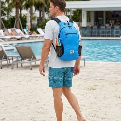 homme avec sac a dos sport bleu clair sur ses épaules au bord de la piscine