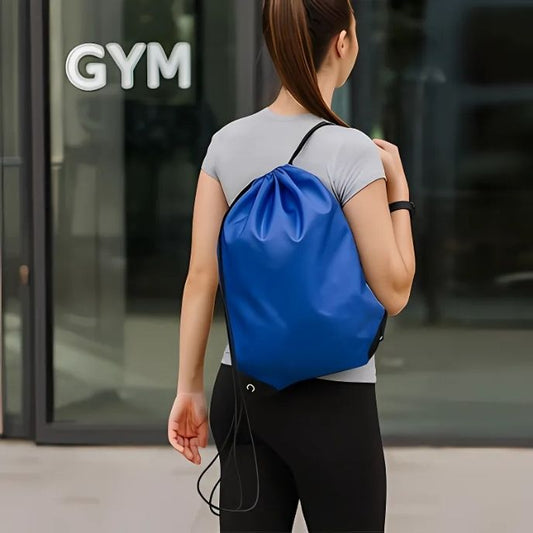 Femme portant un sac a dos sport bleu en toile légère devant une salle de sport