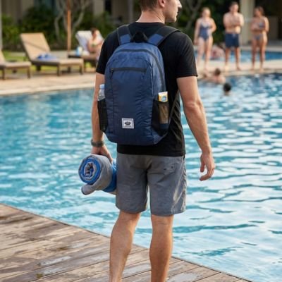 homme avec sac a dos sport bleu foncé sur ses épaules au bord de la piscine