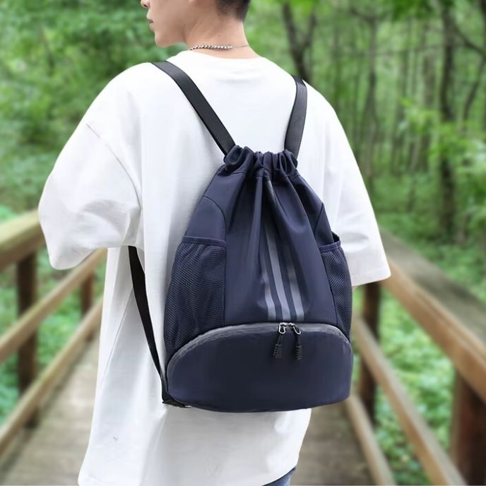 homme porte sac à dos sport bleu sur un pont dans une foret