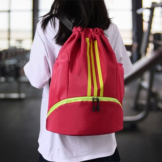 femme porte sac à dos sport rose dans une salle fitness