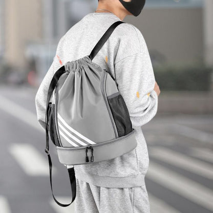 homme avec sac à dos sport gris traverse la rue