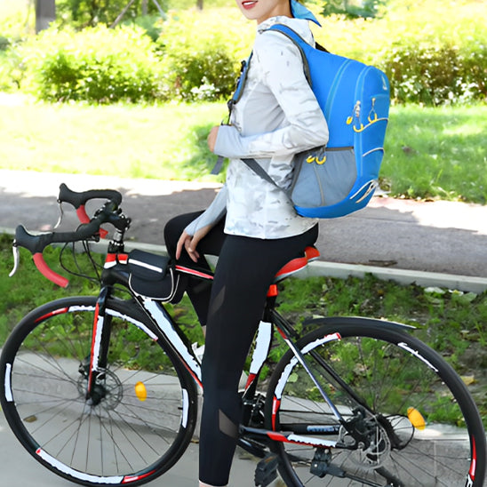 femme assise sur vélo portant sac à dos sport bleu dans un parc