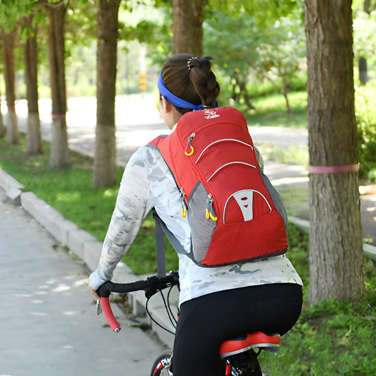 femme cycliste portant sac à dos sport rouge dans un parc