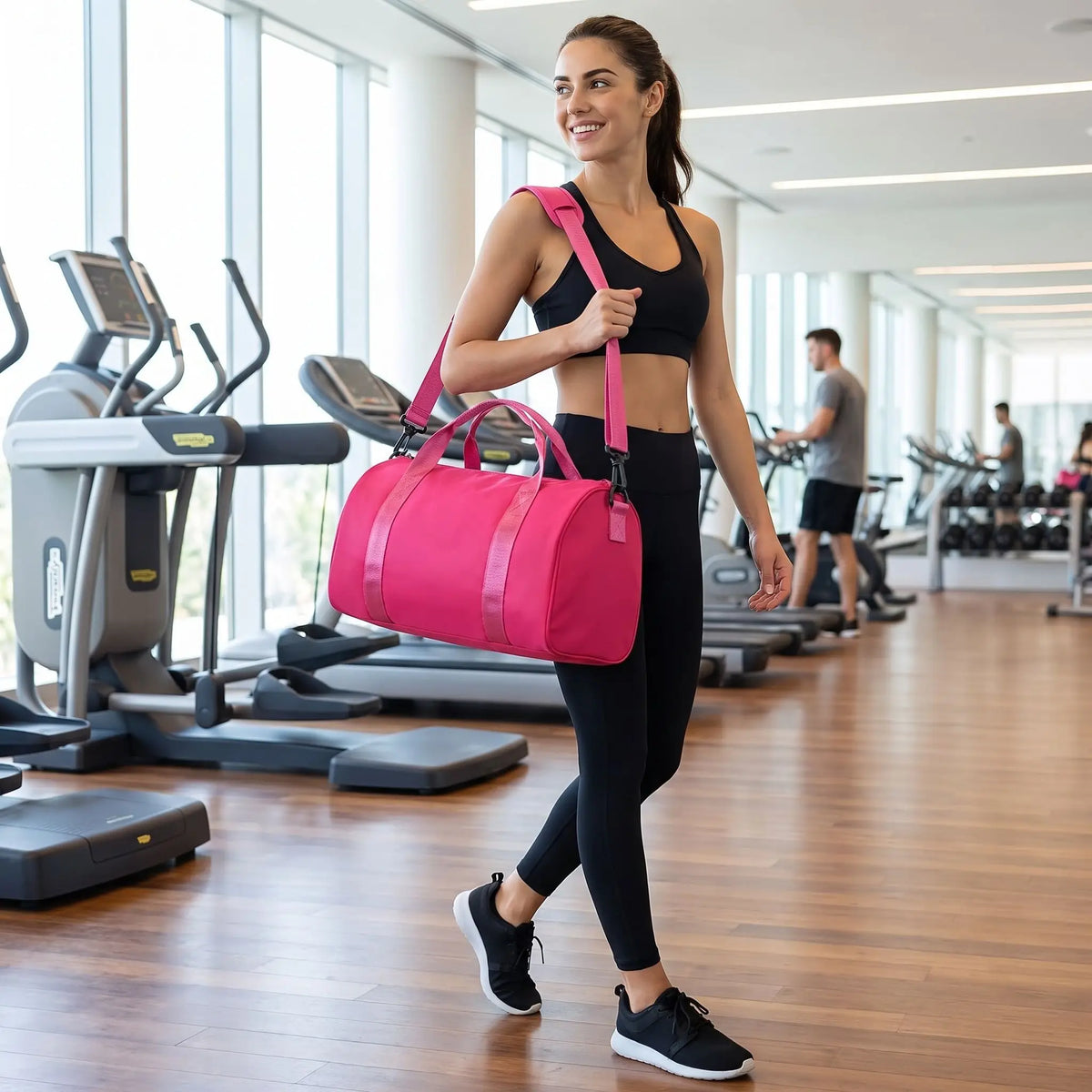sportive porte sac de sport rose fushia sur son épaule dans salle de fitness