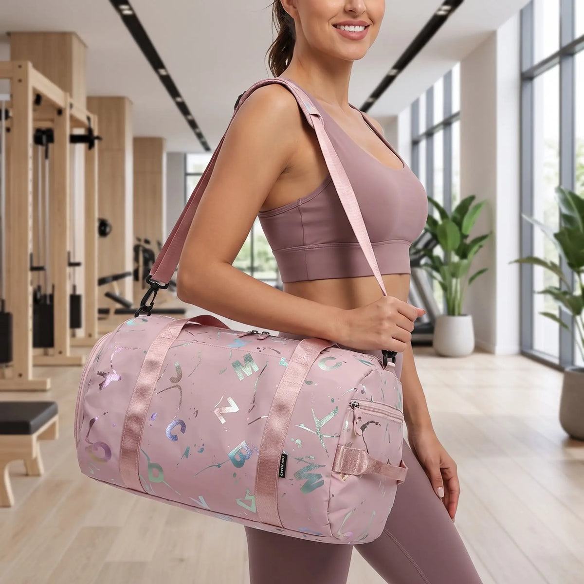 femme fitness habillée en rose avec sac de sport fitness rose sur son épaule dans une salle de fitness