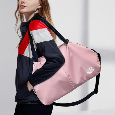 femme porte sac de sport femme rose à l'épaule portant une tenue de sport