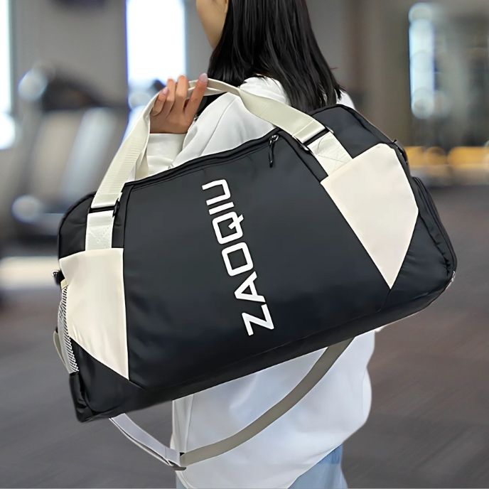 Femme portant sac de sport noir avec bandoulière sur son épaule dans salle de fitness