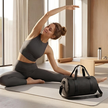 femme sur tapis fait du yoga avec sac de sport fitness noir à côté d elle