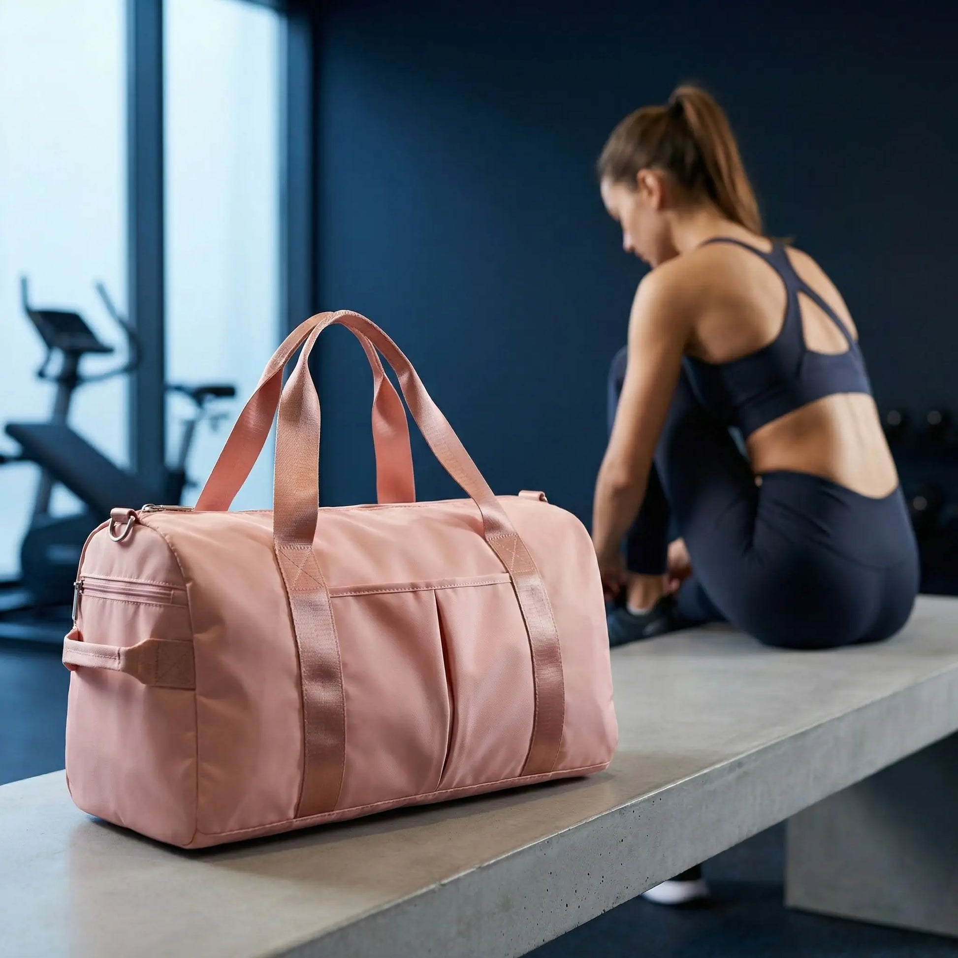femme attache ses chaussures avec sac de sport à côte d elle