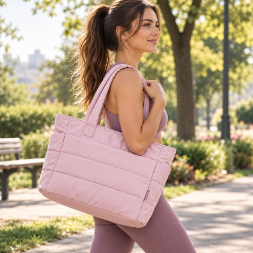 femme porte sac de sport fitness rose sur son épaule dans un parc