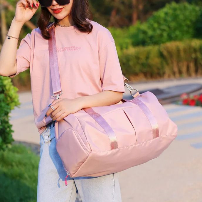 femme avec sac de sport rose sur son épaule dans un jardin