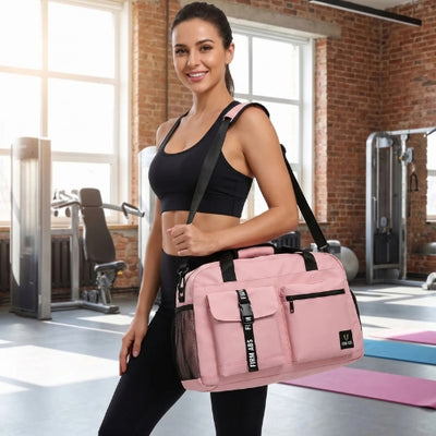 femme sportive habillée en noir avec sac de sport fitness rose sur son épaule dans une salle de fitness