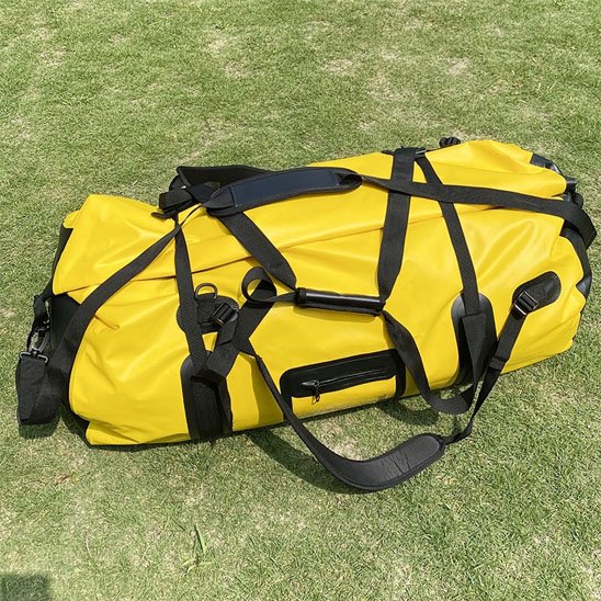 sac de sport fitness jaune posé sur une pelouse verte prêt pour l’entraînement