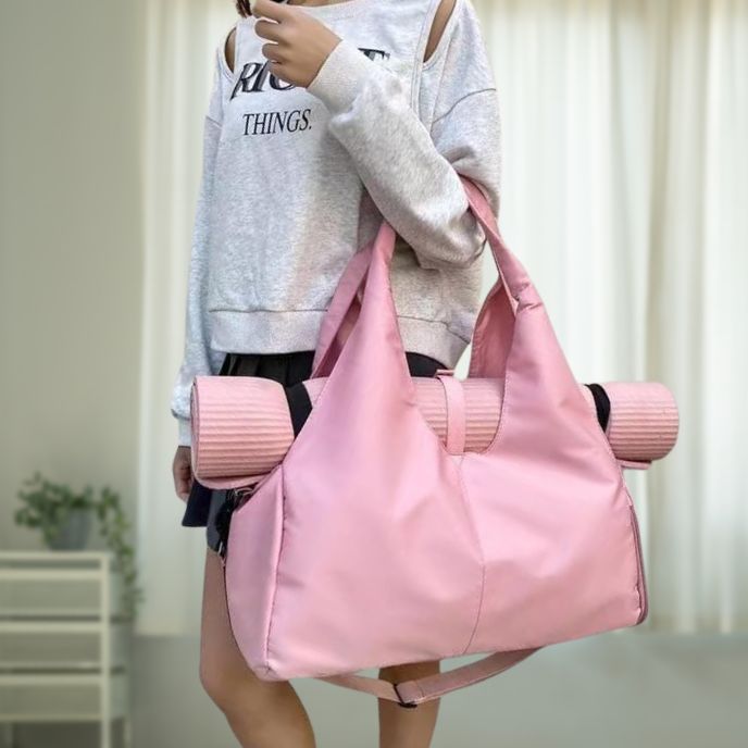 femme porte sac pour tapis yoga rose au coude dans sa chambre