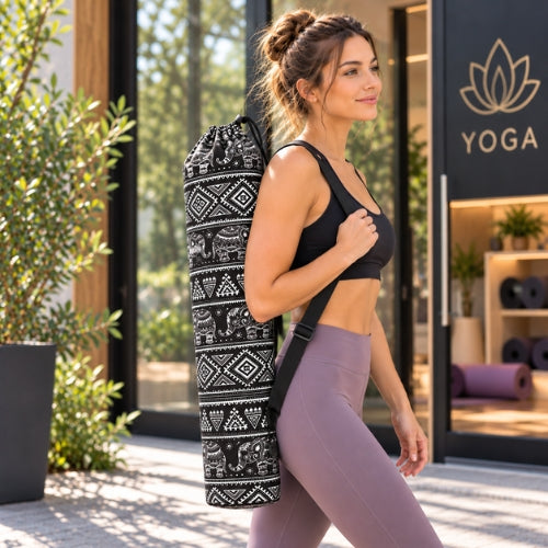 Femme avec sac yoga noir et balnc sur son épaule marchant vers son cours de yoga