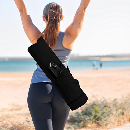 Sac yoga noir porté à l épaule par une femme sac de tapis de yoga pour entraînement en plein air