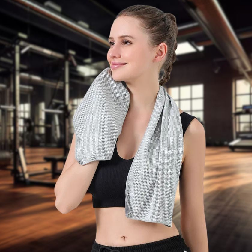 femme sportive essuie son visage avec serviette de sport gris dans une salle de fitness