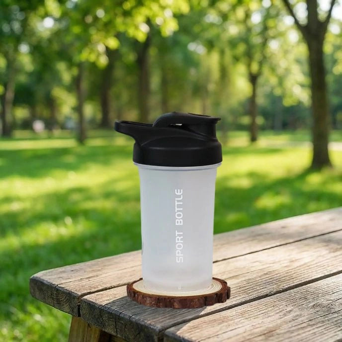 shaker proteine blanc miniboost posé sur une table dans un parc