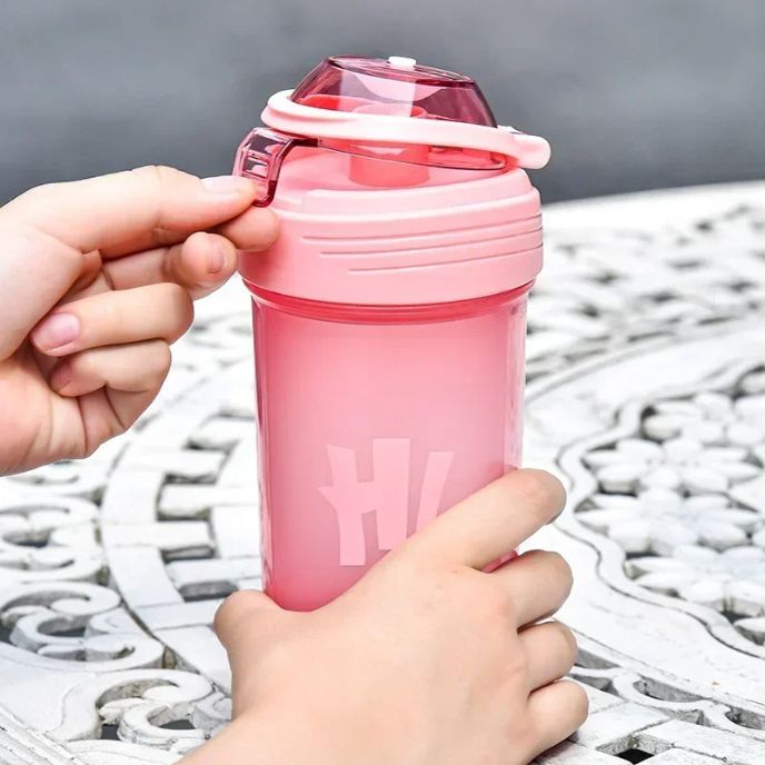 Main ouvrant un shaker rose avec bouchon vissé