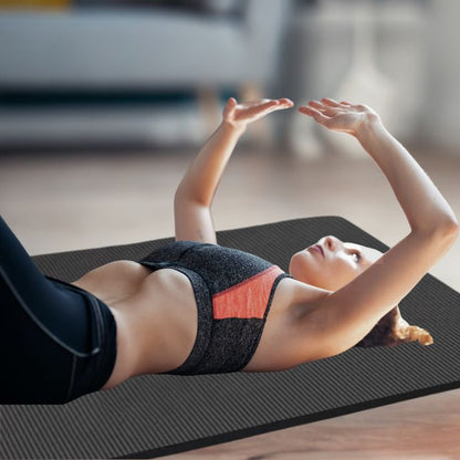 femme sur grand tapis de gym en position couchée sur le dos bras en haut