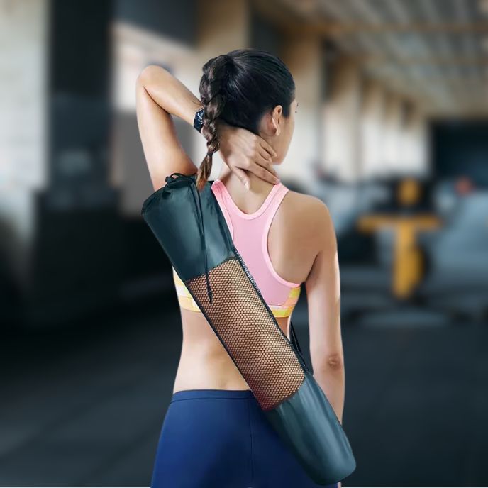 femme porte tapis pilates enroulé et rangé dans son sac sur son dos