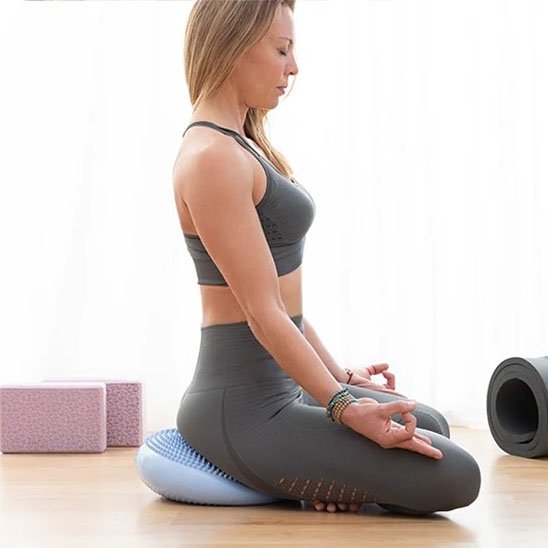 Femme assise en méditation sur un tapis pour pilates pour améliorer l alignement et le confort