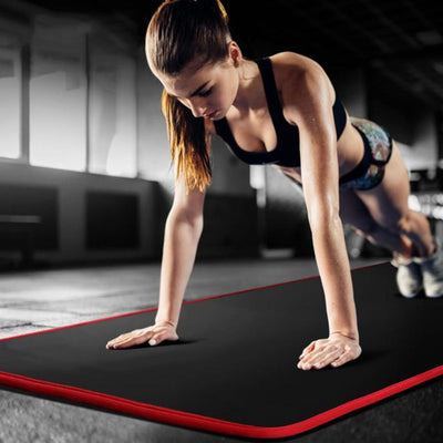 femme sur tapis pour gym noir en position de pompes